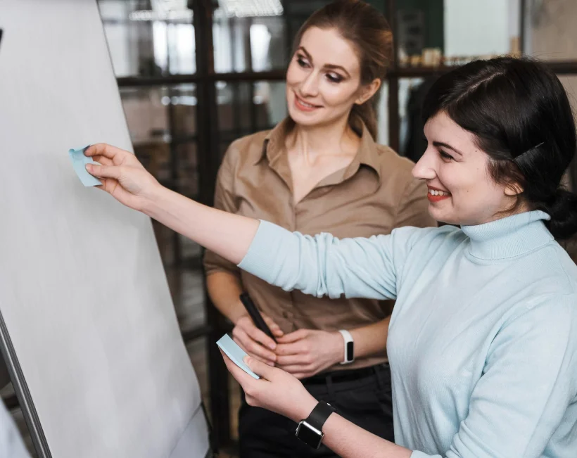 Mulheres a colar post-its em quadro | Serviço de Ações de Formação e Sensibilização | Psicofoz - Guarda